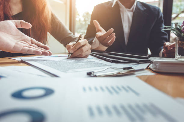 Two people engage in a business discussion, with one person signing a document.